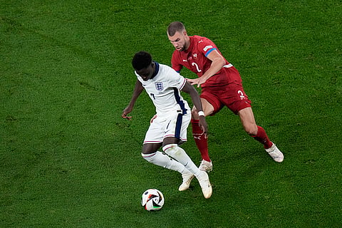 Bukayo Saka is challenged by Strahinja Pavlovic